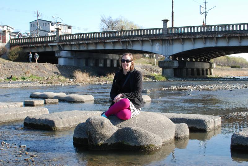 Katie resting on a turtle in the river
