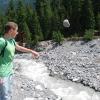 Joe tries to start a rock slide into the river